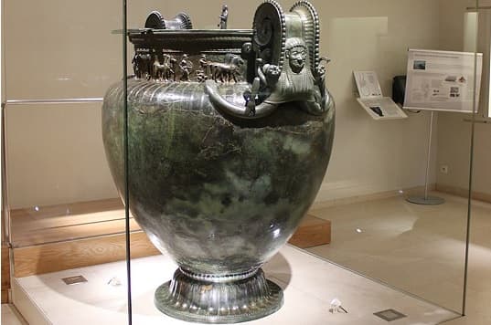 The Vix Krater, a large ancient Greek bronze vessel decorated with intricate relief scenes, depicting warriors, gods, and animals.