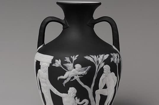 A blue and white cameo glass vase depicting figures and animals in intricate detail, known as the Portland Vase, housed in the British Museum.